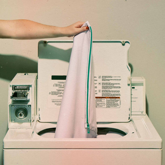 Woman placing the pillow protector in a washing machine